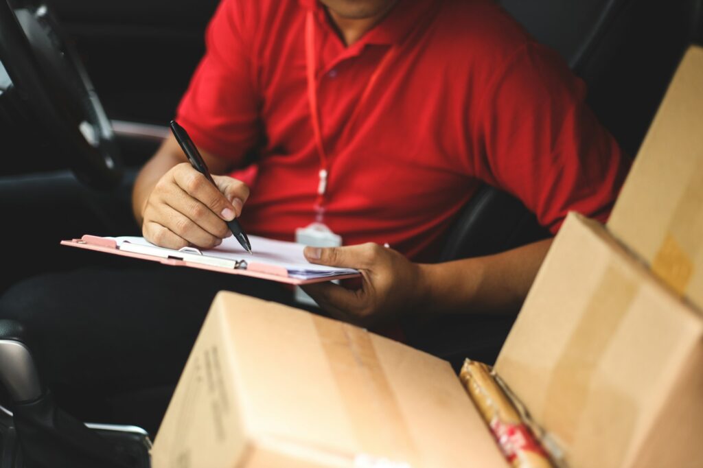 Courier sign shipment document in the car